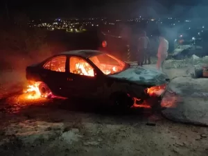 جنوب نابلس، مستوطنون يرسمون رسائل كراهية ويشعلون النار في سيارة.